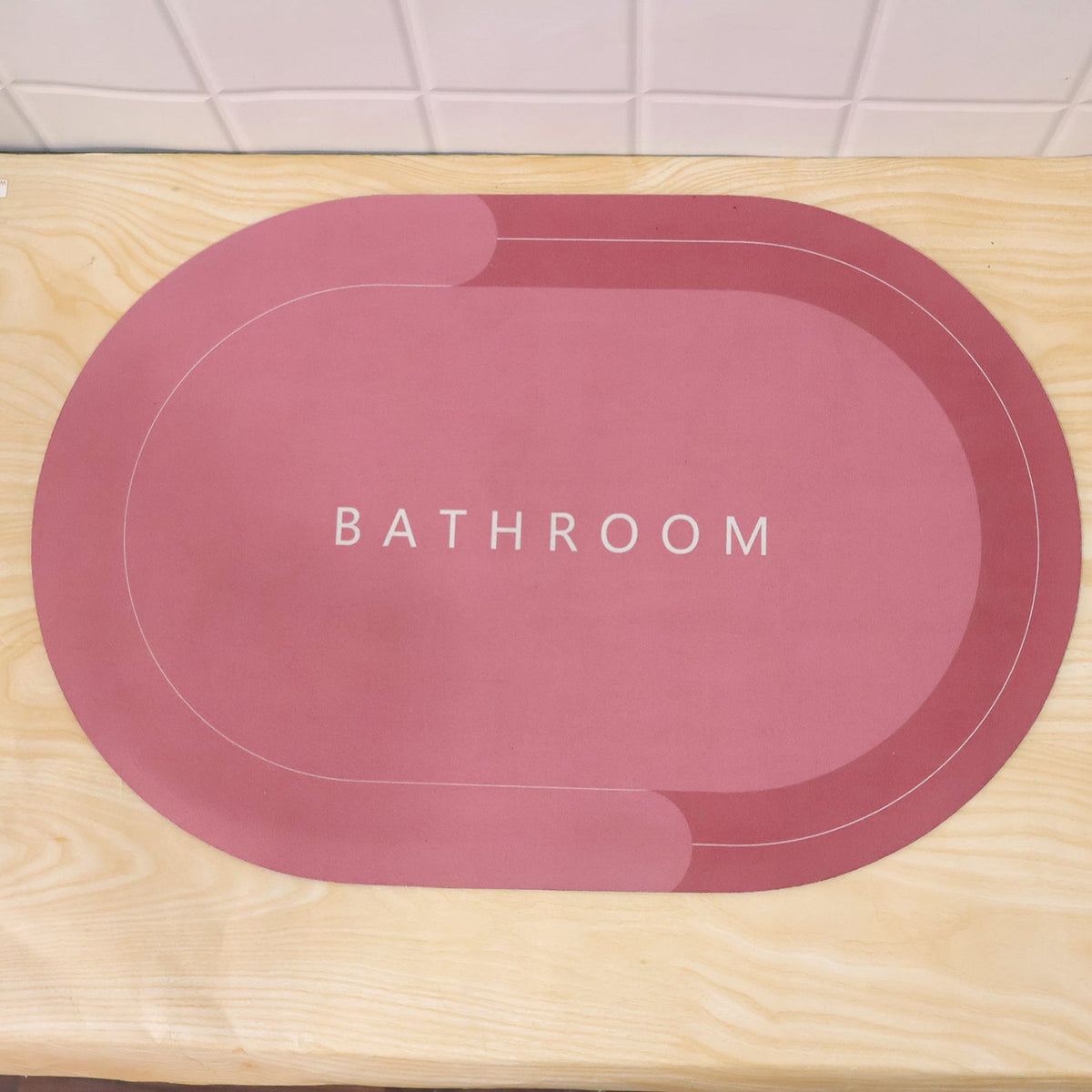 Two-tone oval bathroom rug by Wukusy, water-absorbing and anti-skid mat in beige and gray, 58.5x39 cm.