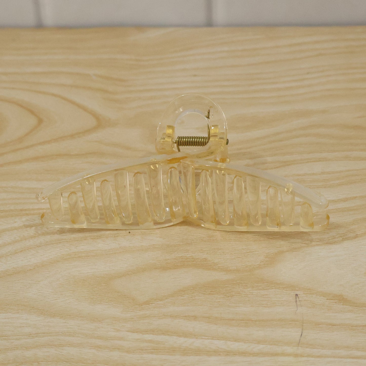Transparent plastic hair clip by Wukusy, a claw-style hair clutcher ideal for women, shown in a close-up image.