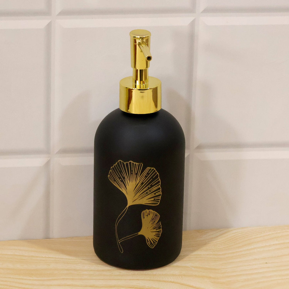 Wukusy manual liquid soap dispenser with leaf design and refillable pump bottle, shown on a countertop.