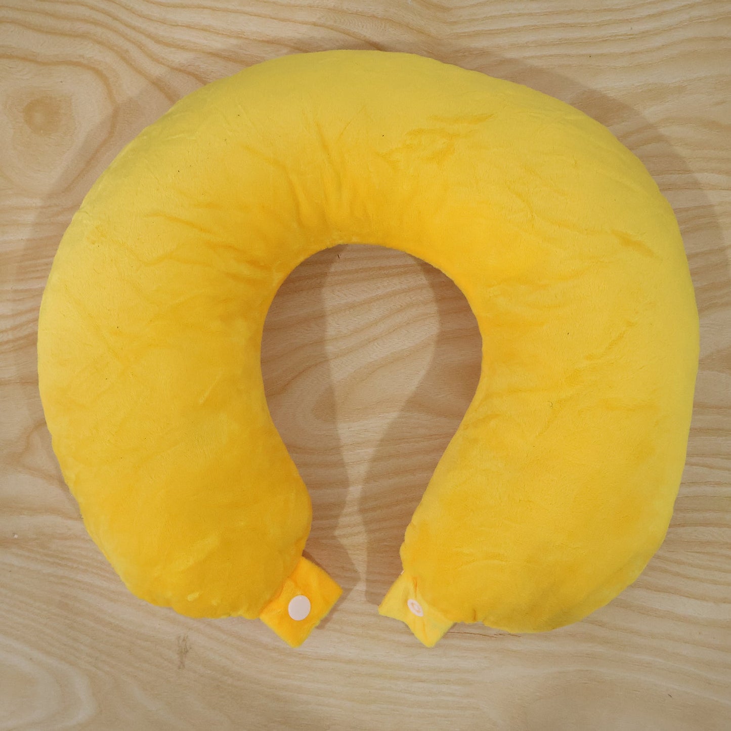 Wukusy soft U-shaped neck travel pillow supporting head and neck during flights with plush cushioning in light blue fabric.