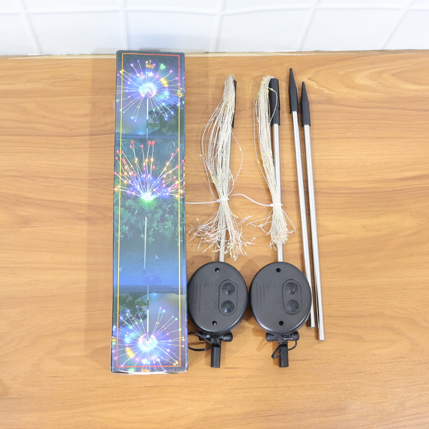 Wukusy solar-powered warm white starburst firework garden lights, 2-piece set with 120 LED bulbs, illuminating outdoor space at night.
