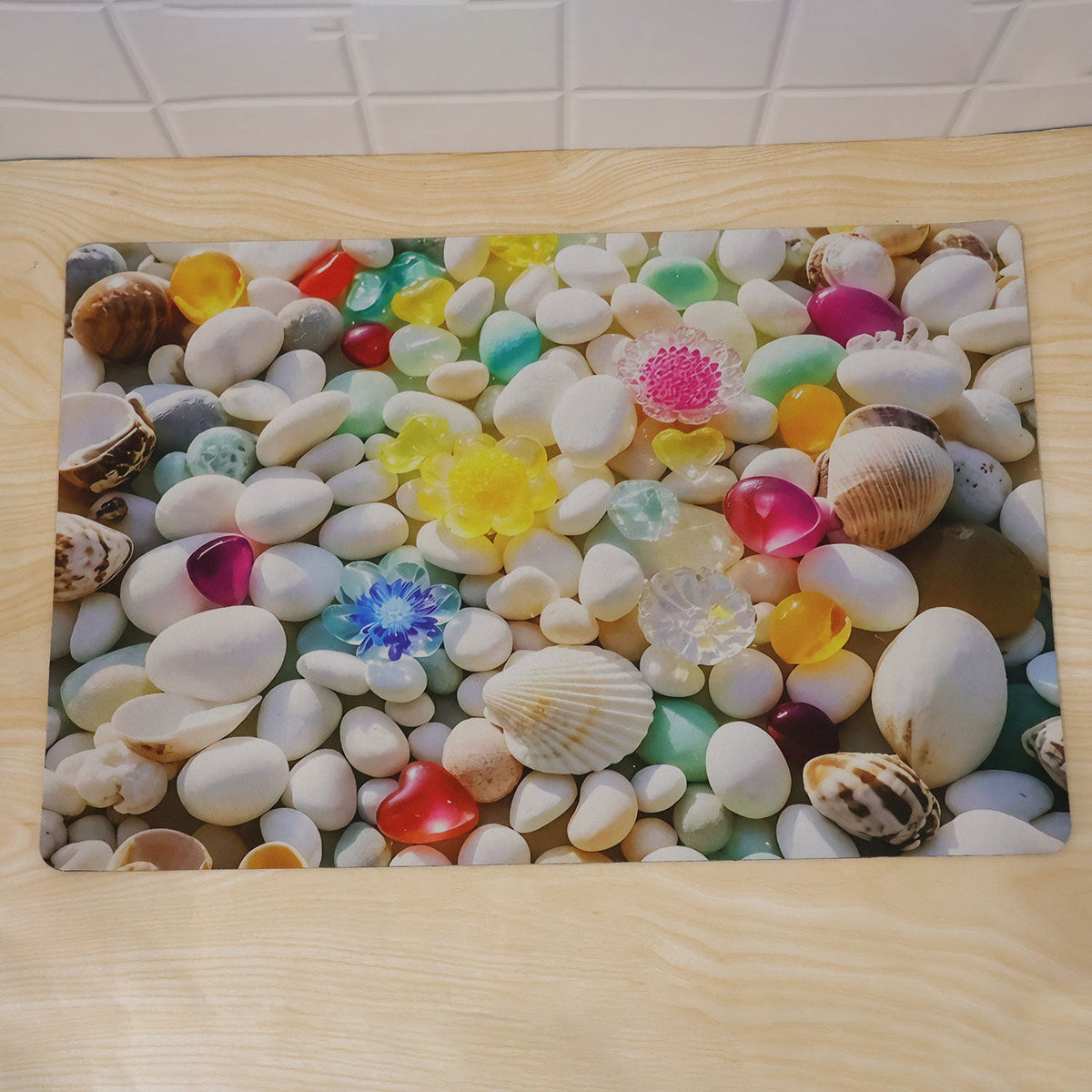 Wukusy 3D pebble stone shower mat with seashell print, water-absorbent rug in 58x38 cm, featuring a textured pebble design and seashell pattern.