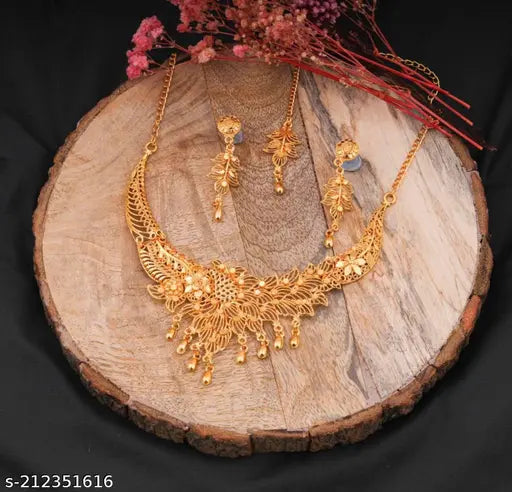 Gold jewelry set for women featuring earrings, necklace, and bracelet from the 19670 brand, showcased on a display stand.