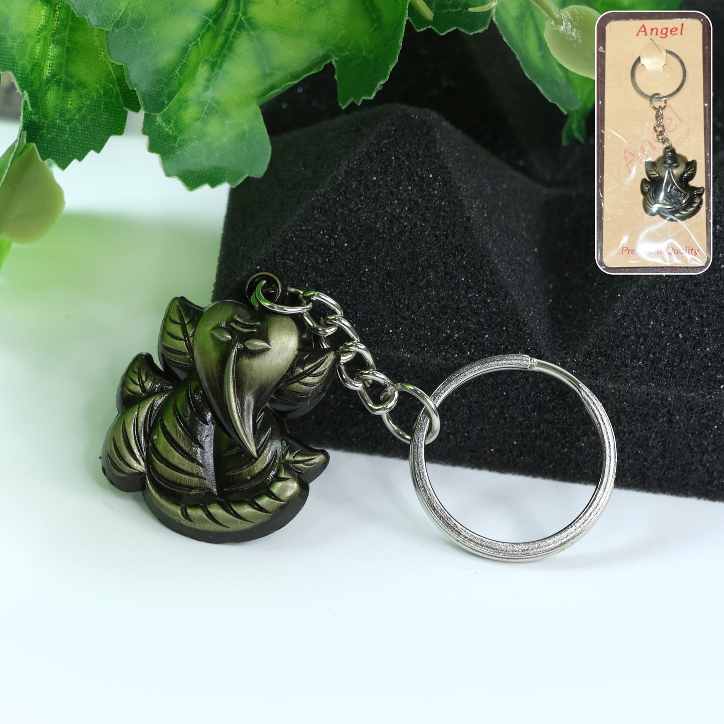 Antique black metal Ganesh face keychain with intricate design, featuring a detailed Hindu deity image on a small keyring.