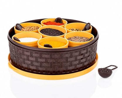 Dropdash plastic masala box with 7 compartments and spoons, used for storing spices in a religious and spiritual kitchen setting.