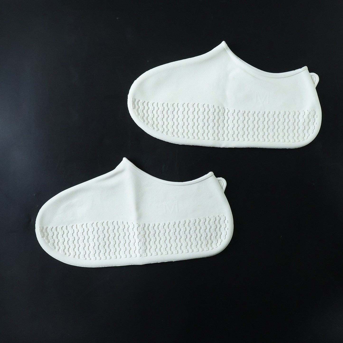 White waterproof silicone shoe covers by Wukusy, medium size, shown on a pair of shoes for protection against water and dirt.