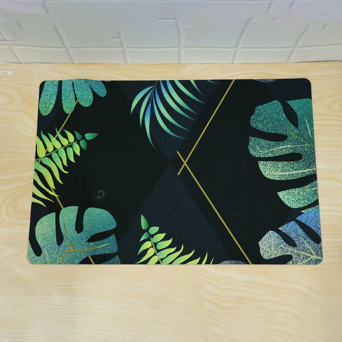 Decorative tropical leaf print floor mat for indoor doorways by Wukusy, 59.5x40 cm, featuring vibrant green tropical leaf design.