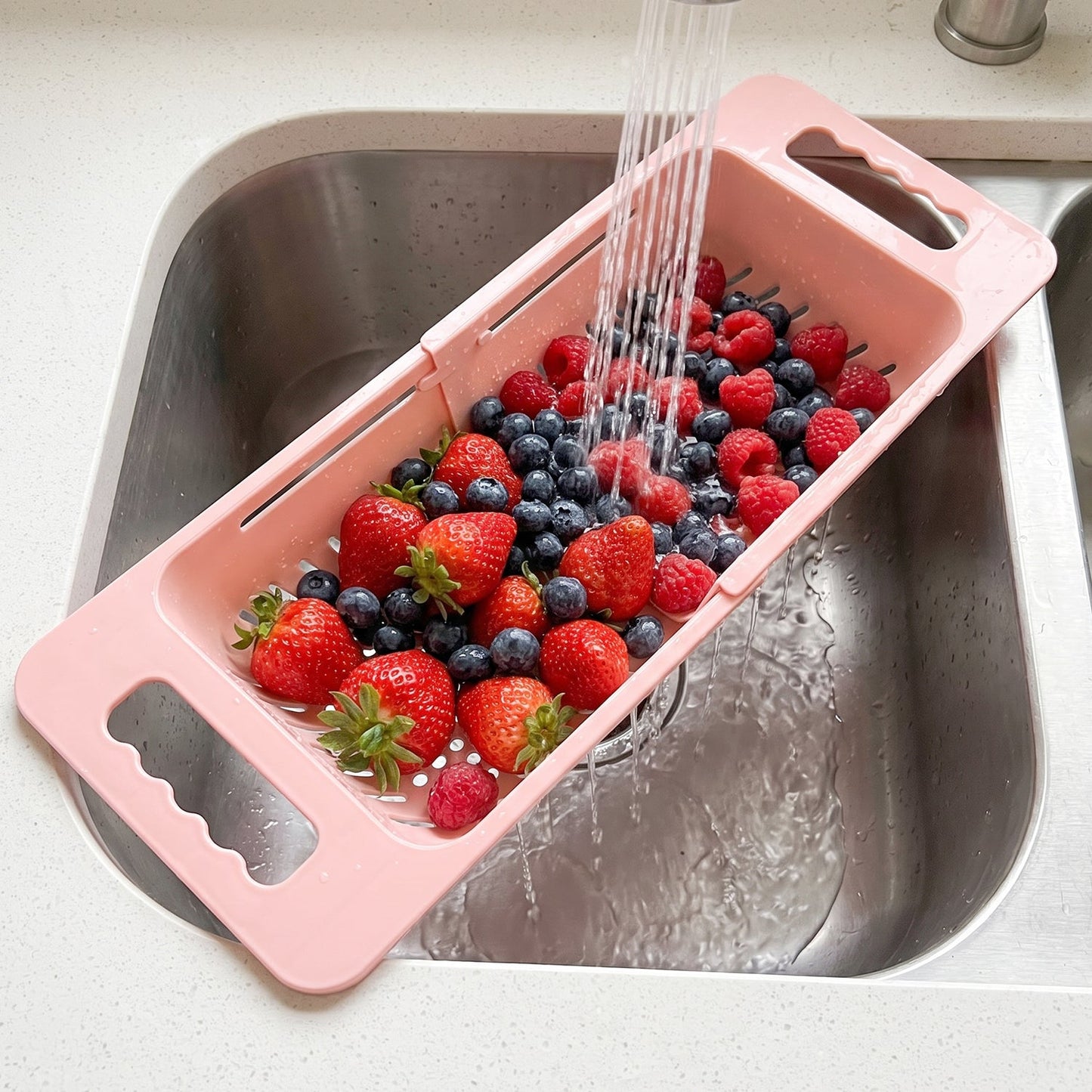 Wukusy adjustable plastic over-the-sink drain basket colander with handles, suitable for rinsing fruits and vegetables.