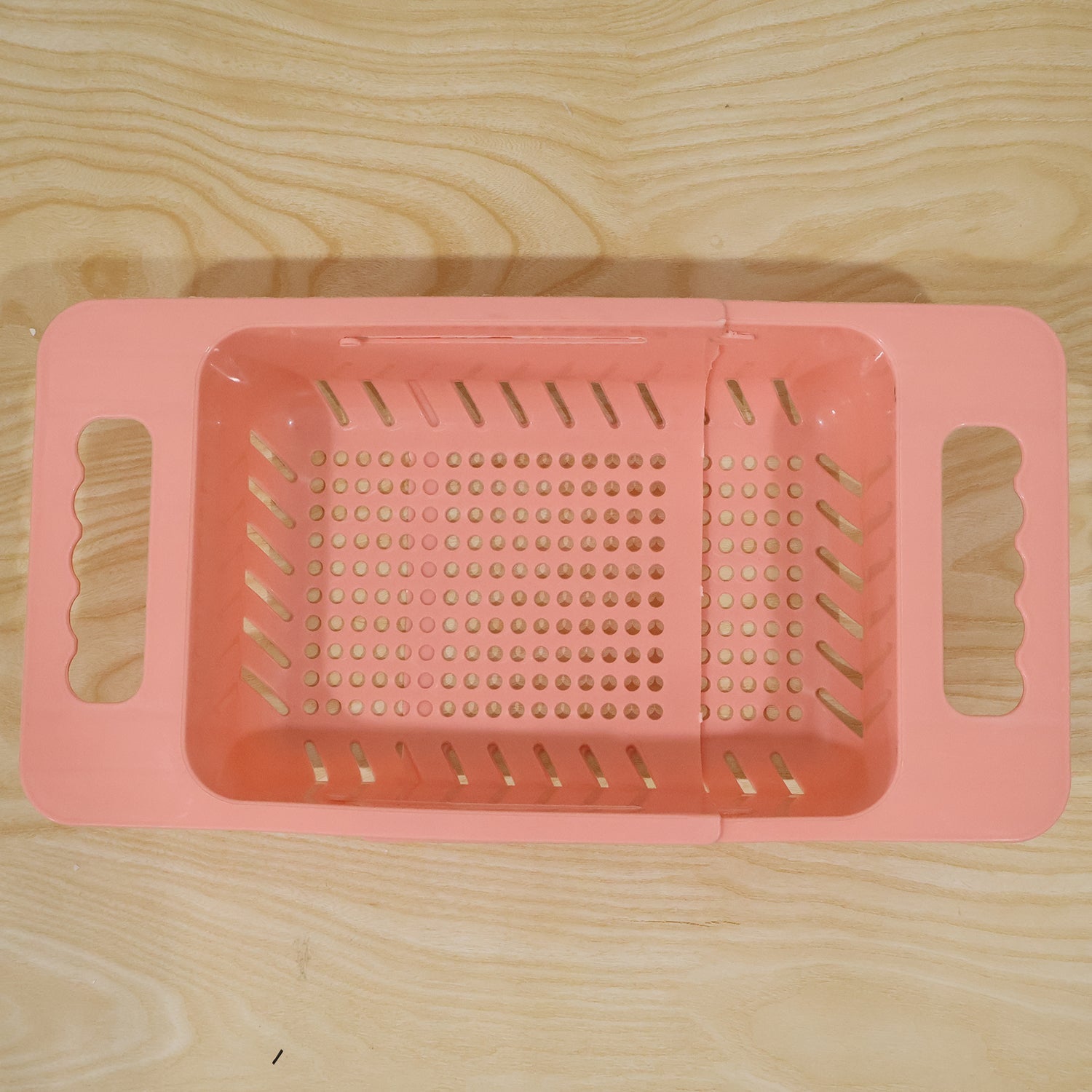 Wukusy adjustable plastic over-the-sink drain basket colander with handles for rinsing and draining food or produce.