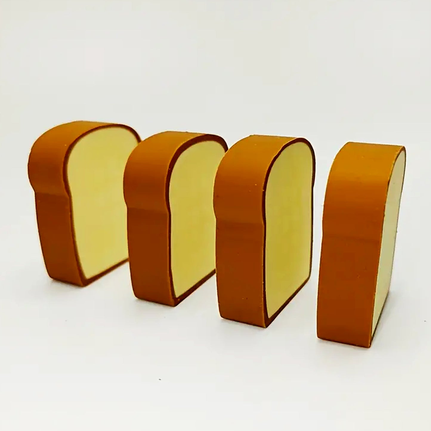 Set of four Wukusy 3D toast bread shape erasers featuring cute cartoon bread designs for kids and students.