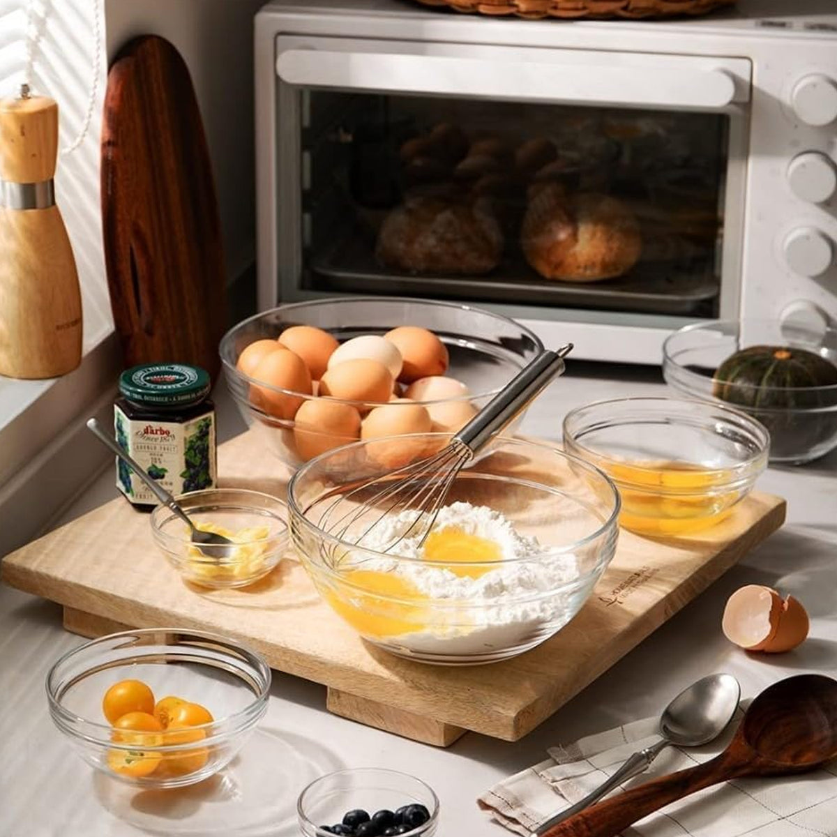 Set of five modern glass mixing and storage bowls with lids by Wukusy, showcasing clear glass bowls in various sizes with secure lids.