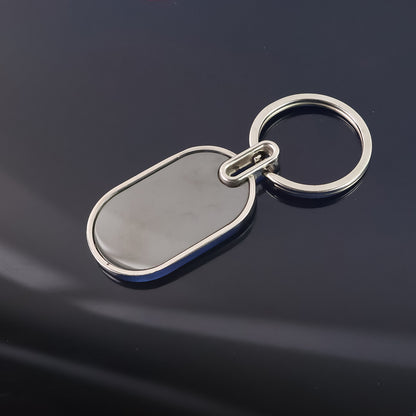 Elegant black and silver oval metal keychain by Wukusy with a sleek, polished finish and a sturdy keyring attachment.