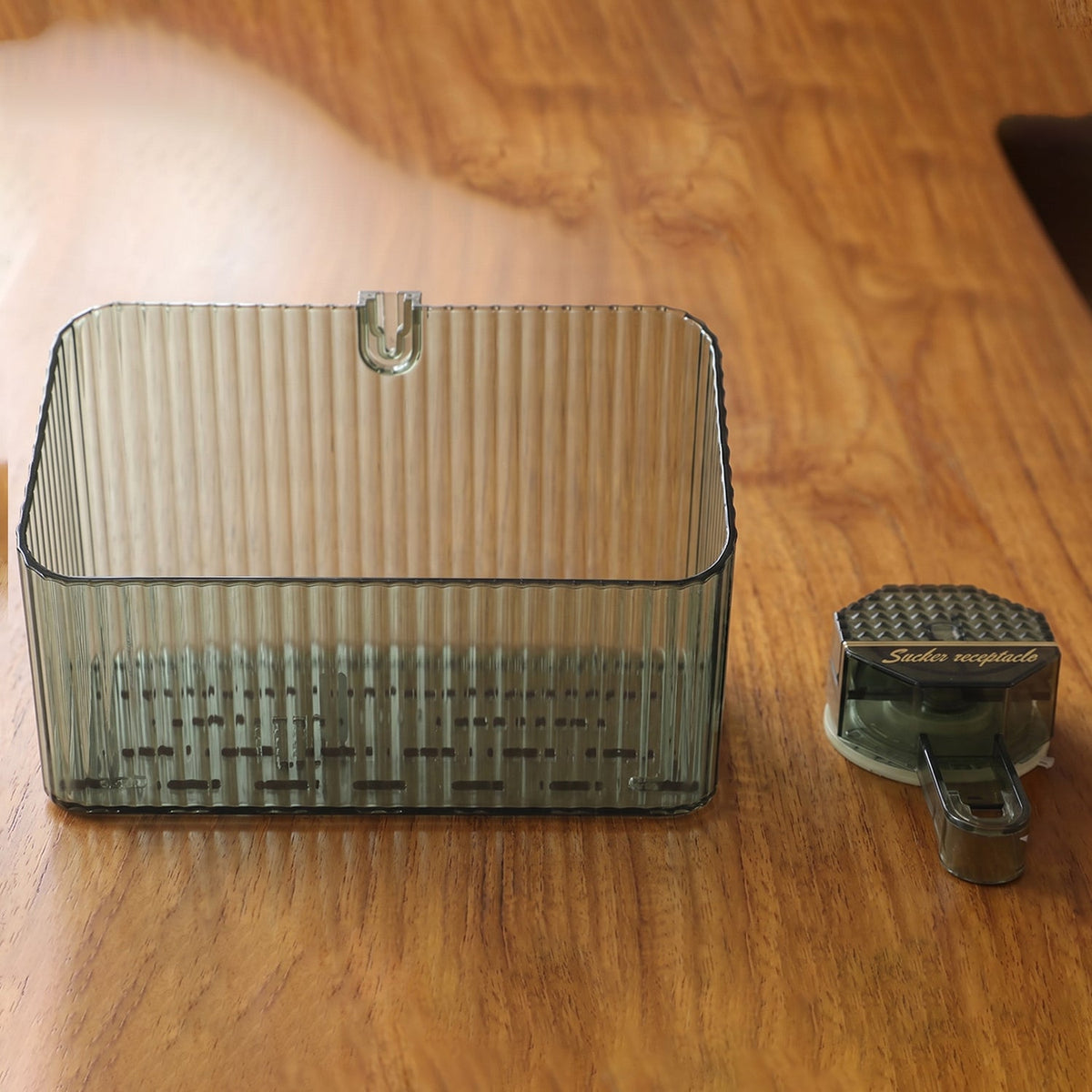 Transparent wall-mounted storage box by Wukusy, ideal for bathroom or kitchen organization, shown mounted on a wall.