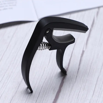 Wukusy 6141 guitar capo with pickup stand and soft pad for acoustic, electric guitar, ukulele, mandolin, and banjo accessories.
