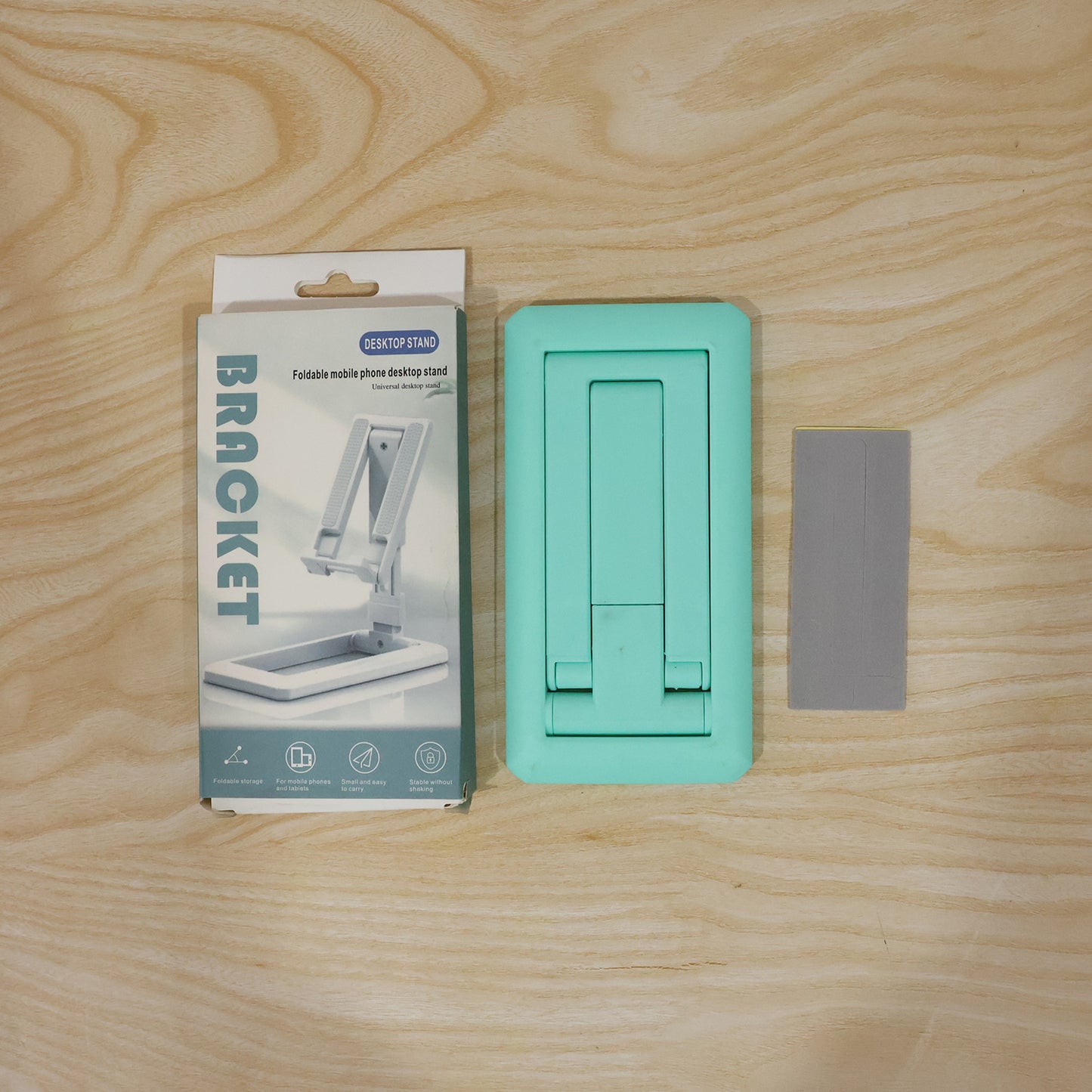 Wukusy foldable plastic mobile phone holder stand on a desk, adjustable for viewing, suitable for office use.