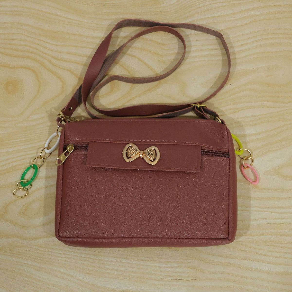 Wukusy women's PU leather sling bag with adjustable strap and bow, featuring a stylish and compact design for casual use.