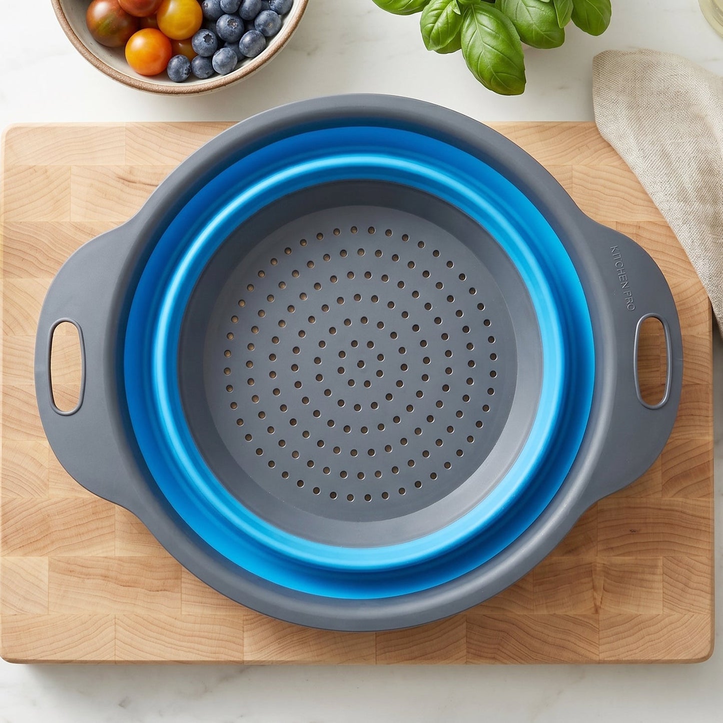 Wukusy foldable silicone kitchen strainer with handles, space-saving drainer for rinsing vegetables and pasta.