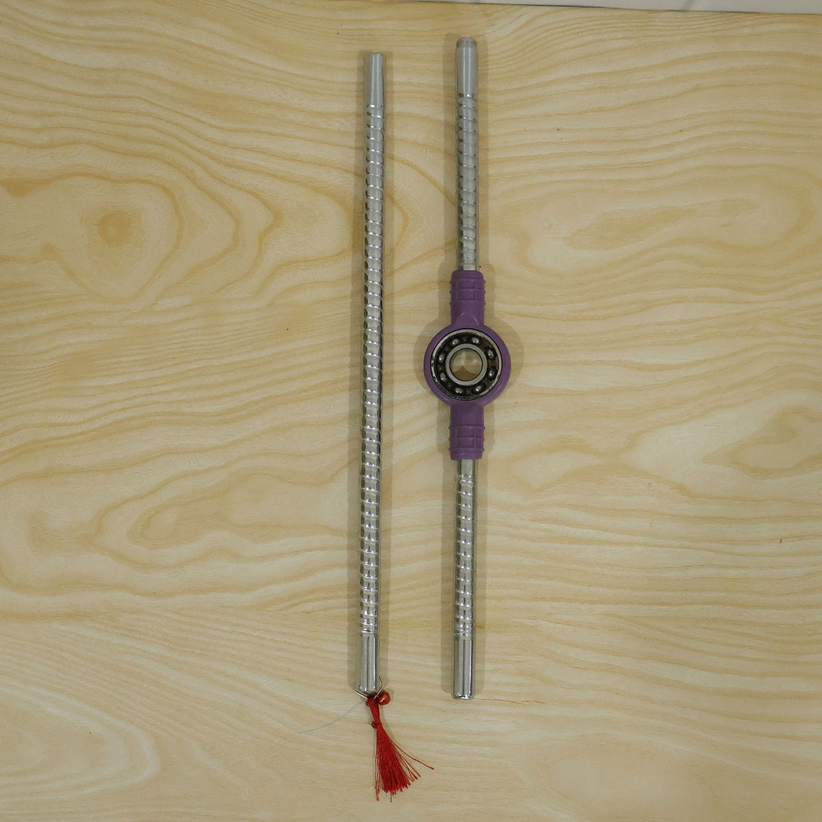 Wukusy steel dandiya sticks with textured grip, bearing center, and decorative tassels for traditional dance.