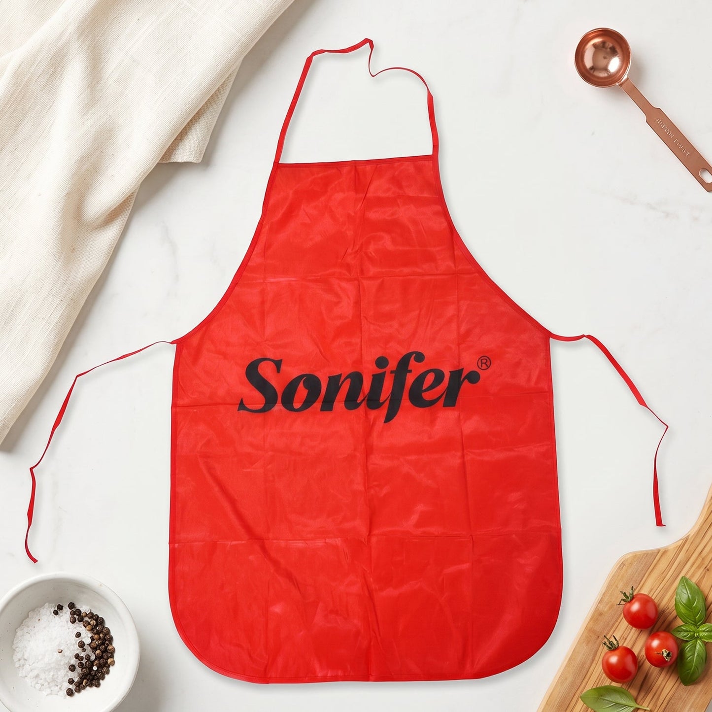 Wukusy reusable cooking apron with front pocket and adjustable neck strap, shown on a person in a kitchen setting