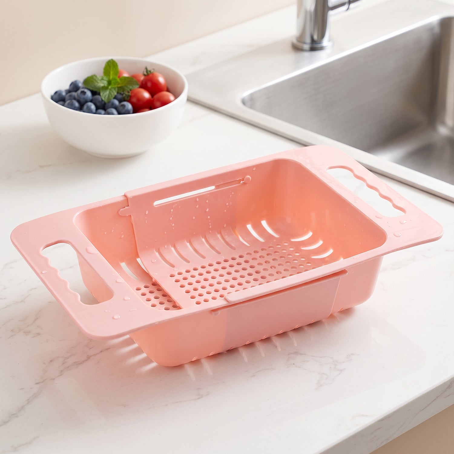 Wukusy adjustable plastic over-the-sink drain basket colander with handles for draining fruits, vegetables, and pasta.