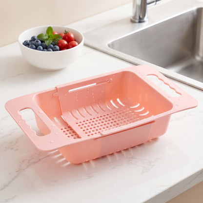 Wukusy adjustable plastic over-the-sink drain basket colander with handles for draining fruits, vegetables, and pasta.