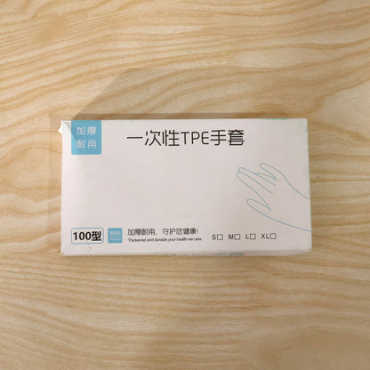 Box of 100 Wukusy disposable gloves for kitchen and household use, showing clear, white gloves ready for cleaning or food handling.