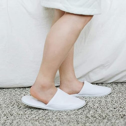 Pair of disposable hotel slippers from Wukusy, soft fabric slippers for guest comfort, shown in a clean, open pair.