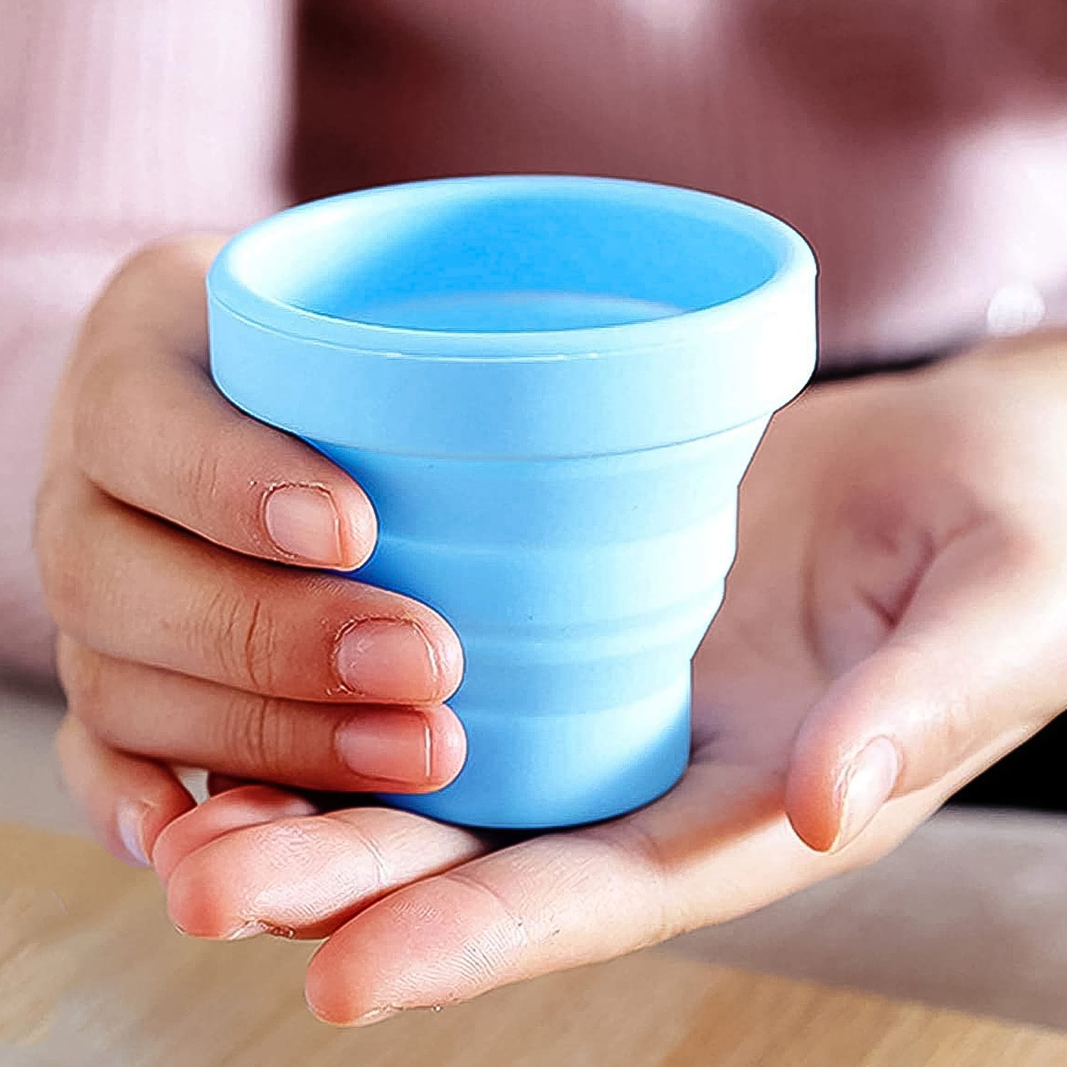 Wukusy round silicone foldable travel mug without lid, compact and flexible for home and kitchen use, shown in a foldable form.