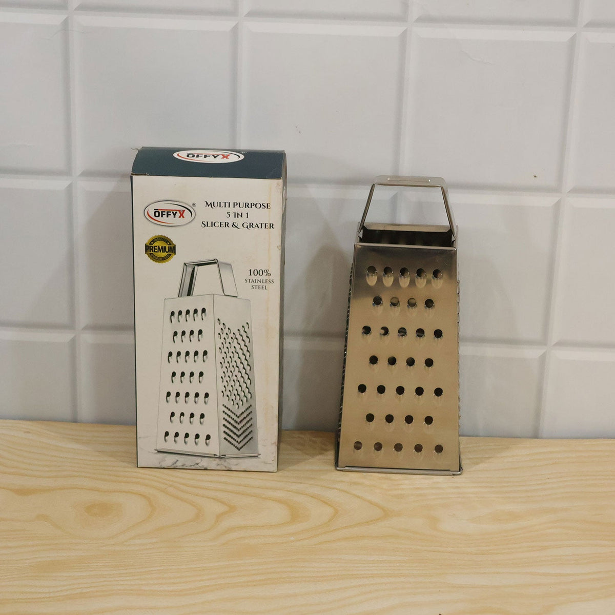 Wukusy 5-in-1 steel box grater with vegetable slicer for cheese shredding and food prep, shown with grated cheese and sliced vegetables