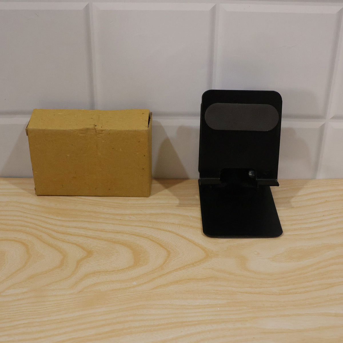 Wukusy foldable metal mobile phone stand with adjustable angle, desk use, compact design, black finish, and secure phone holder.