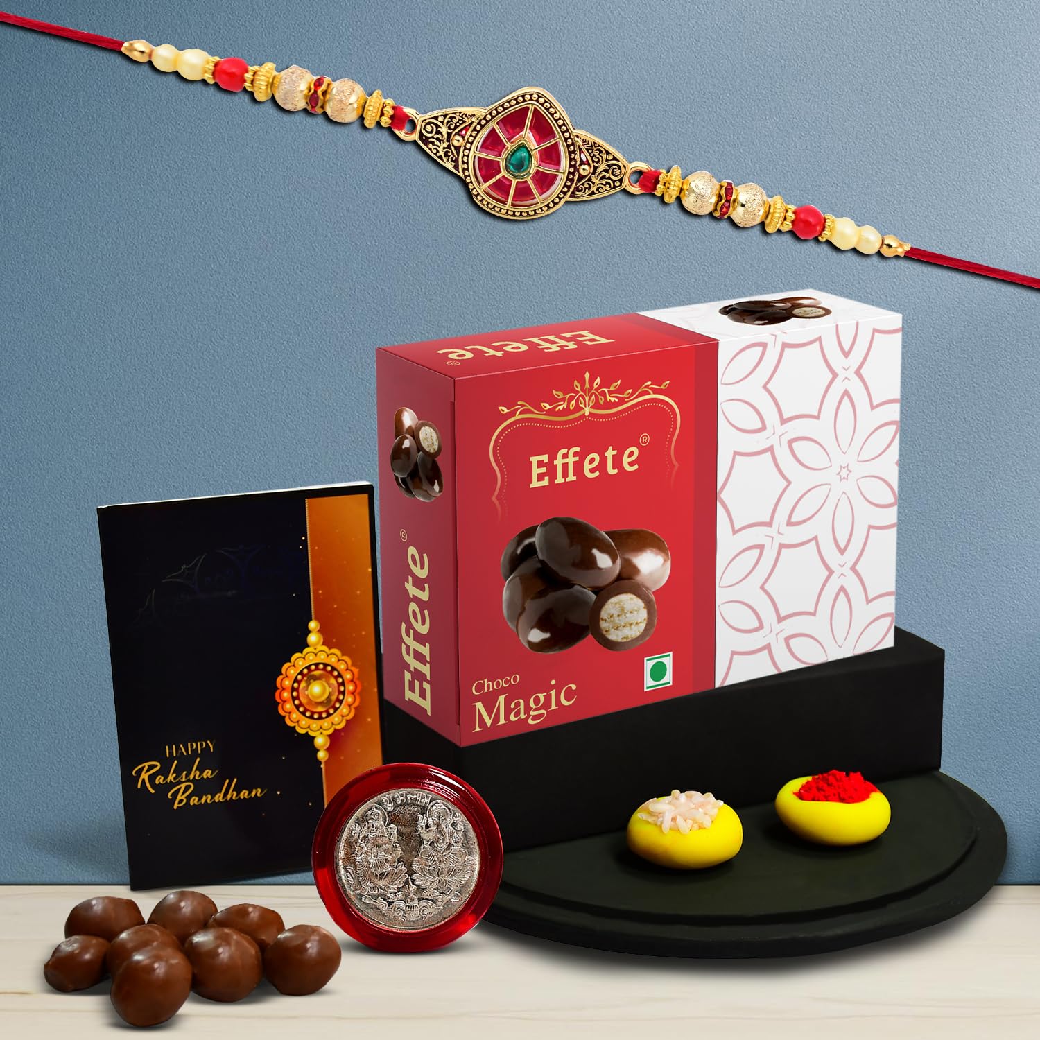 Wukusy Rakhi for brother and Bhabhi set with chocolate, pooja coin, greeting card, and sweets for kids and gift-giving.