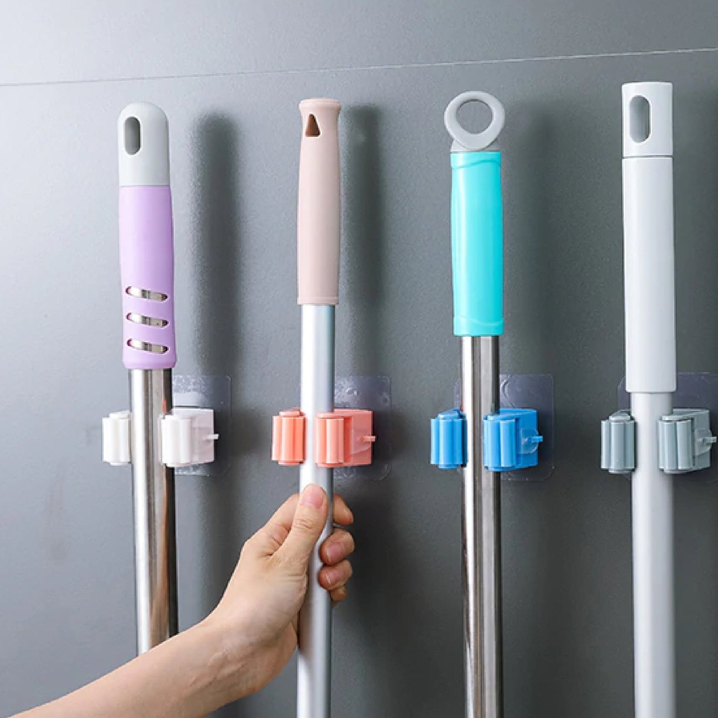 Wukusy Magic Sticker Series self-adhesive mop and broom holder attached to a wall for organized home cleaning tools.