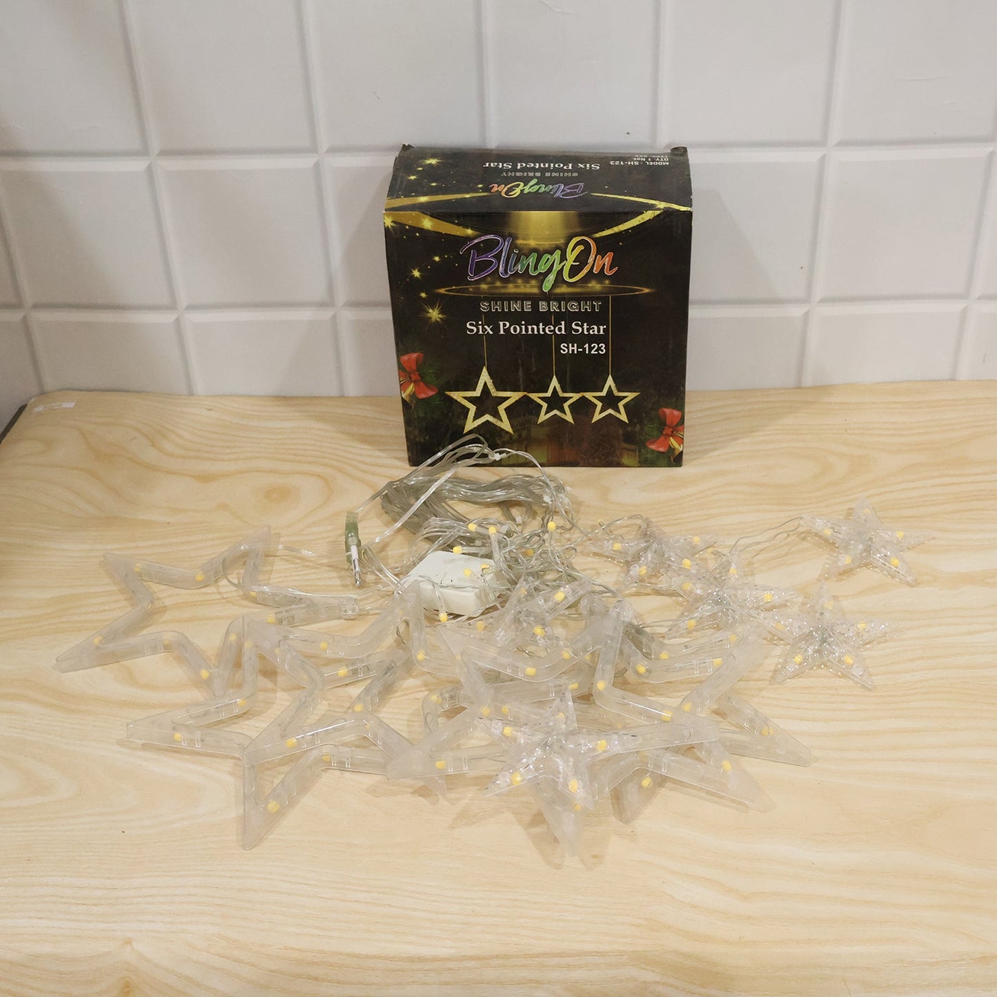 Wukusy white star LED string lights set with warm fairy lights for decoration, hanging with glowing star-shaped bulbs.