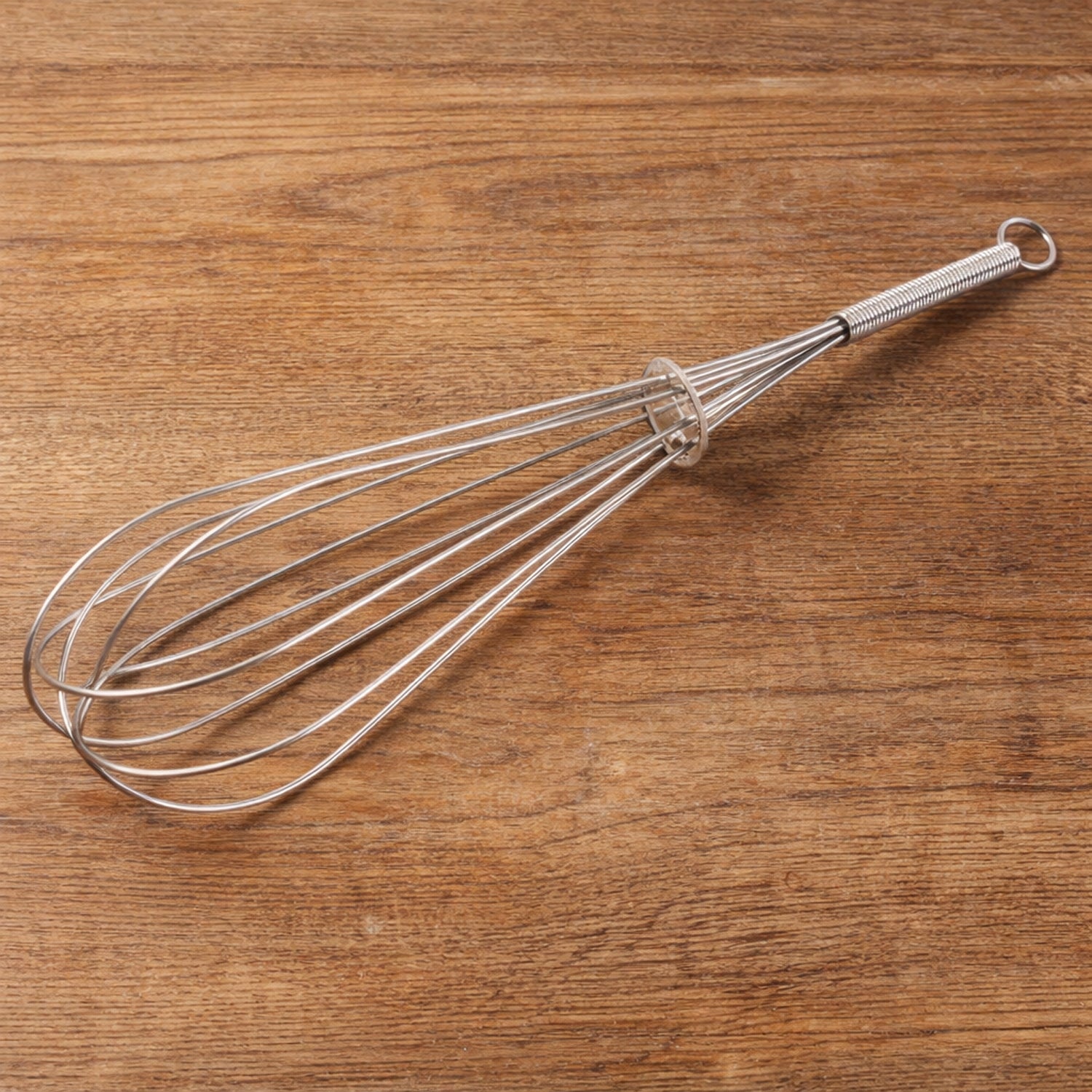 Manual stainless-steel egg beater whisk by Wukusy, showing the sleek, durable handle and wire beaters for mixing eggs and batter.