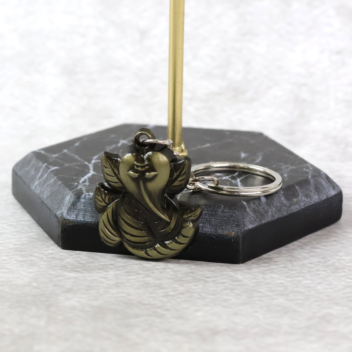 Black metal Ganesh face keychain by Wukusy, featuring intricate antique-style design and detailed craftsmanship.