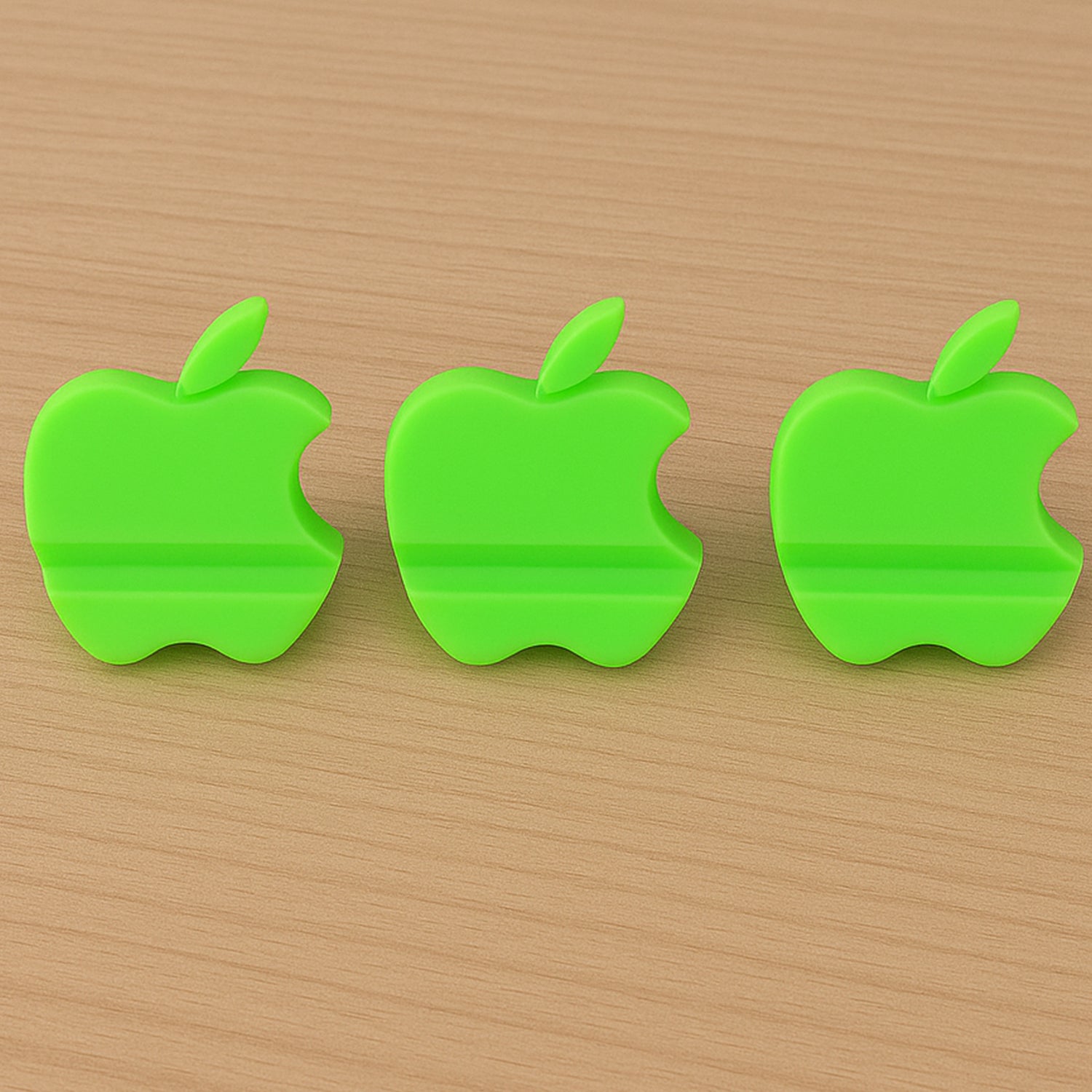 Three colorful apple-shaped plastic mobile phone holders in a mix of vibrant colors, designed for stable phone support.