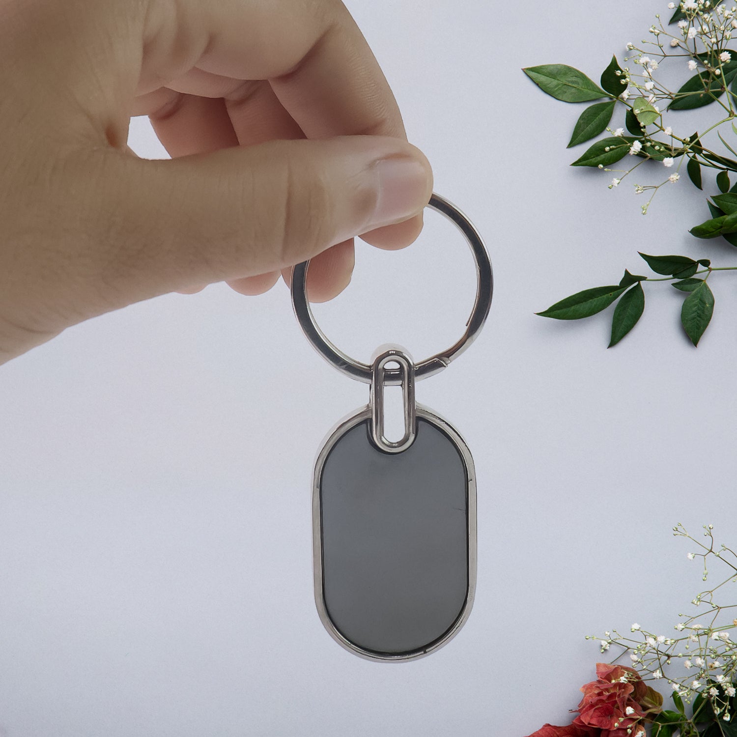 Elegant black and silver oval metal keychain from Wukusy with a sleek, polished finish and sturdy keyring.