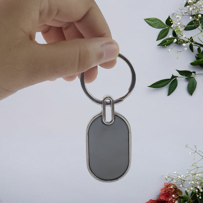 Elegant black and silver oval metal keychain from Wukusy with a sleek, polished finish and sturdy keyring.
