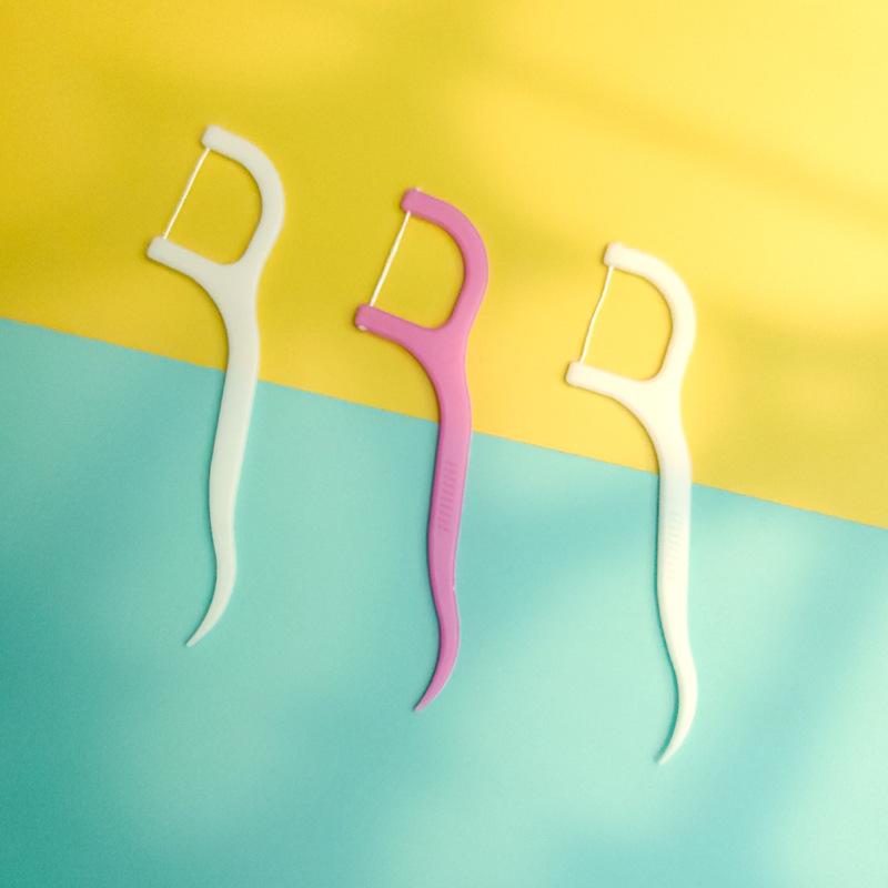 Wukusy Oral Care dental floss and toothpick sticks for oral hygiene, featuring compact, easy-to-use dental tools.