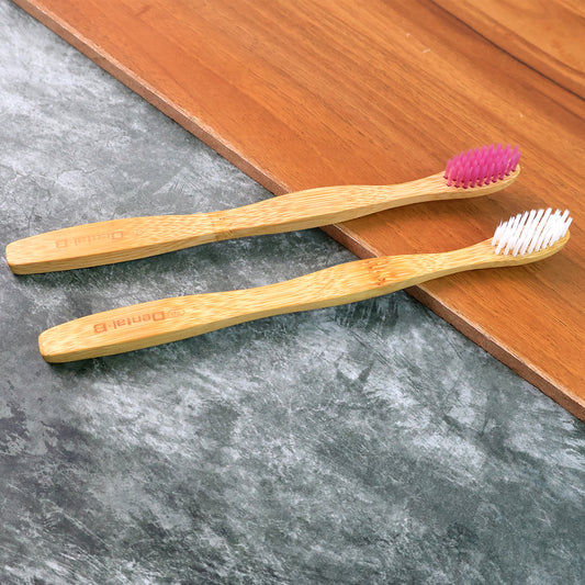 Two Wukusy eco-friendly bamboo toothbrushes with medium bristles, natural bamboo handles, and soft bristle heads for oral care.