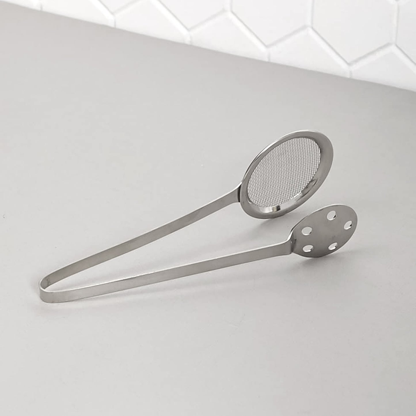 Wukusy Apex stainless steel skimmer serving tong for kitchen use, with a long handle and metal scoop for serving and skimming food.