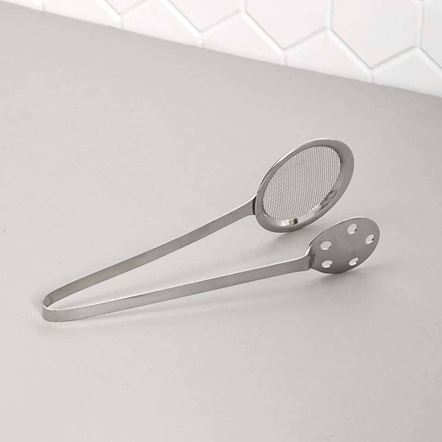 Wukusy Apex stainless steel skimmer serving tong for kitchen use, with a long handle and metal scoop for serving and skimming food.