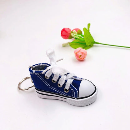Wukusy Mini Shoes Keychain, stylish travel accessory for backpacks, featuring a small, detailed shoe design.