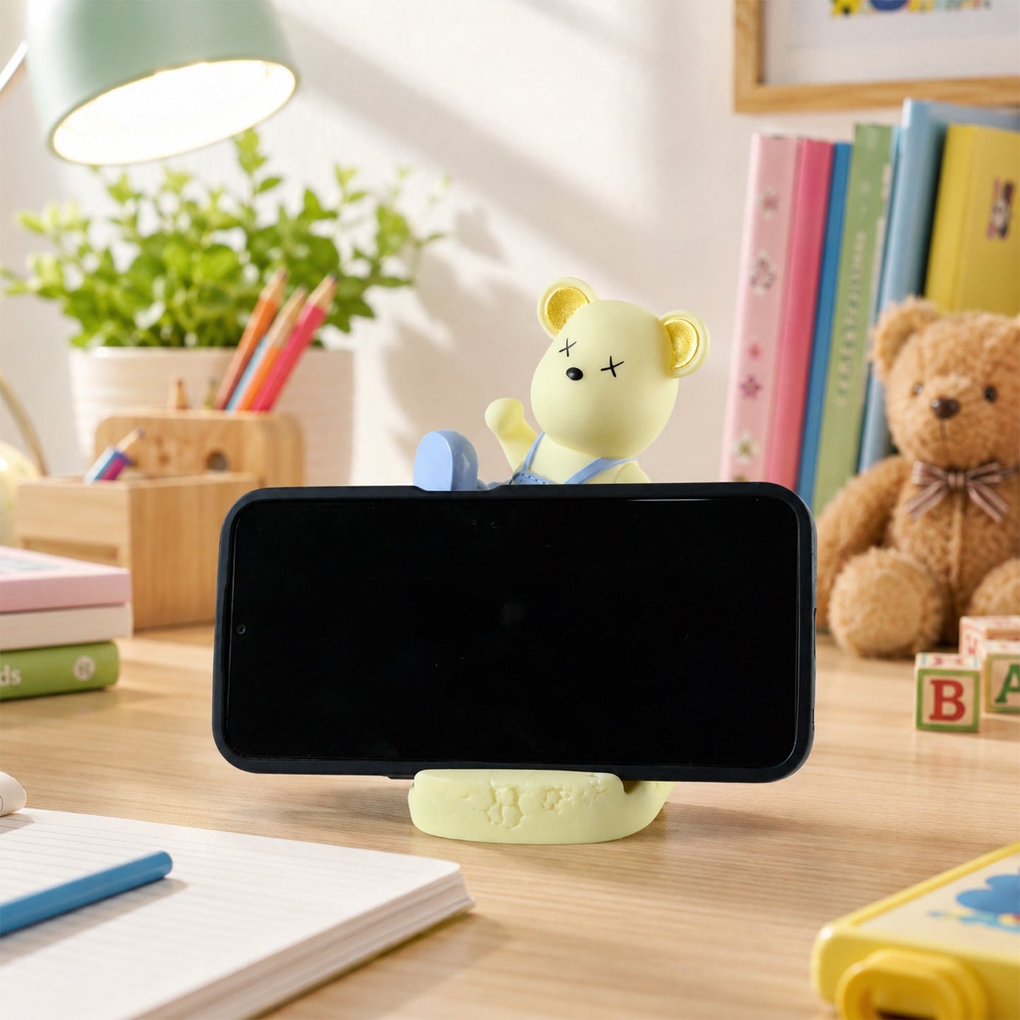 Wukusy magnetic bear LED night lamp and phone stand on a desk, providing soft light for kids' room or bedside use.